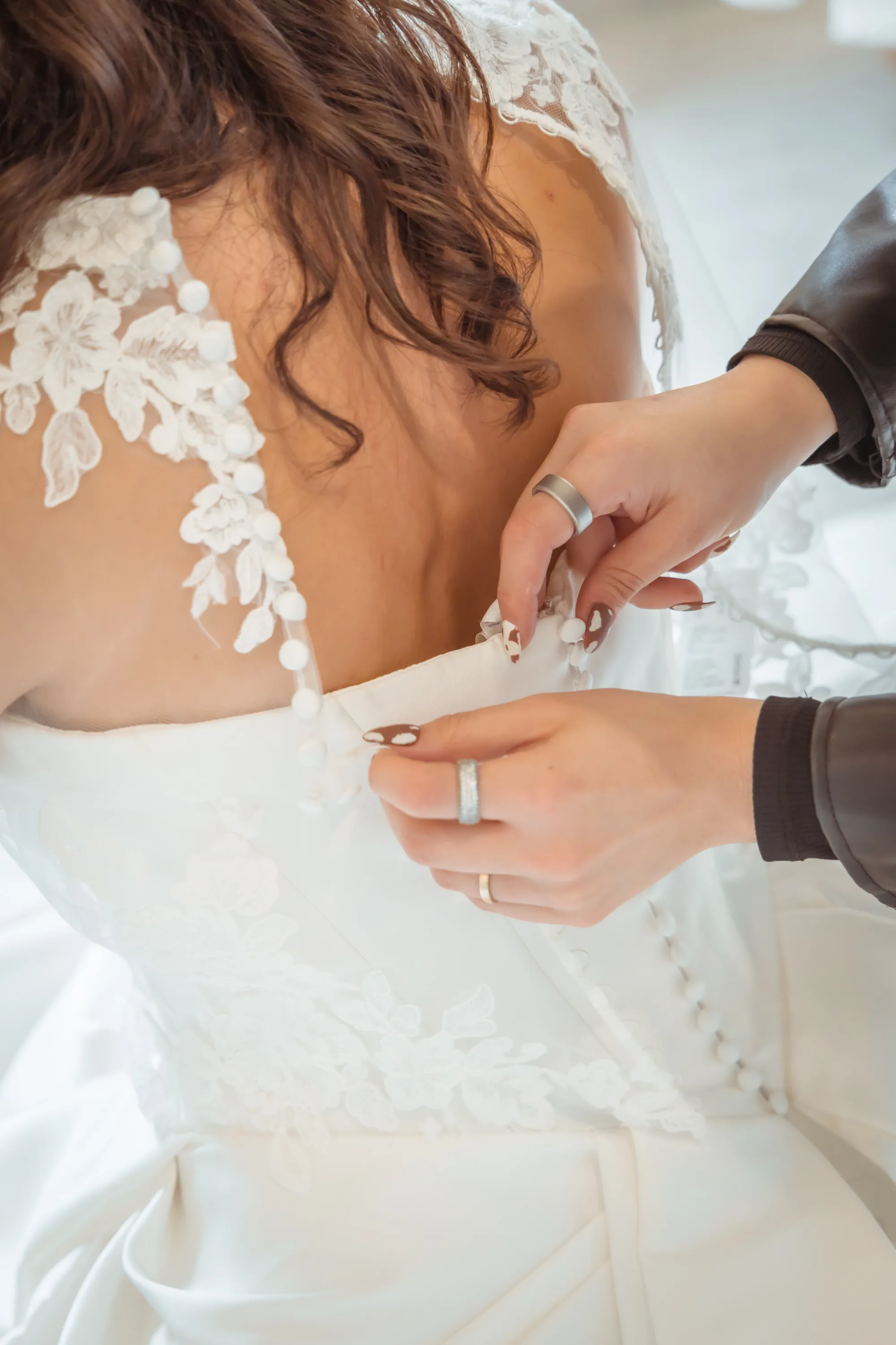 Detalle real del Atelier de Rabling Bridal, novia siendo abotonada en su vestido