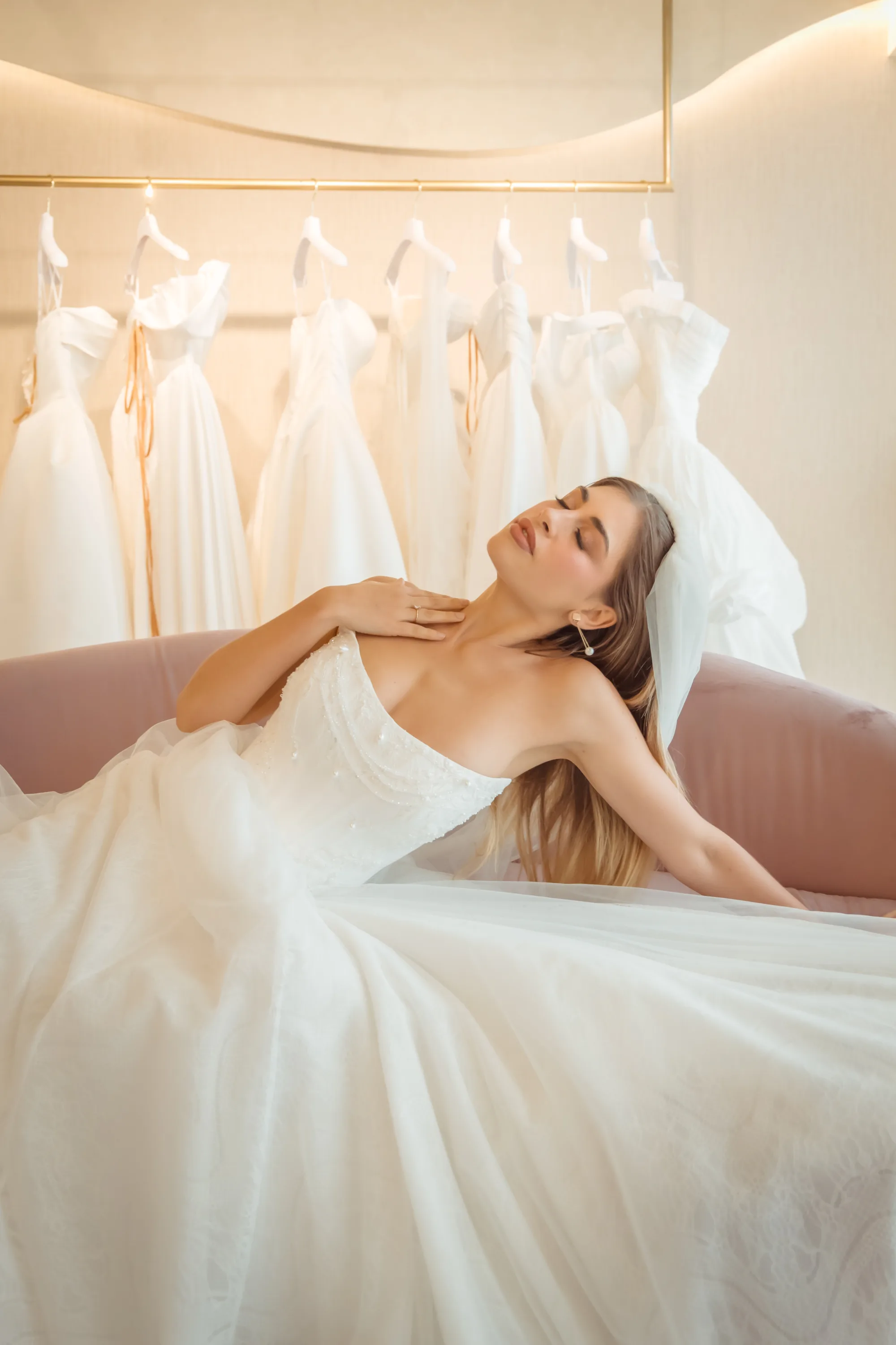 Novia recostada en el sofá del Showroom, fotografía real de Rabling Bridal